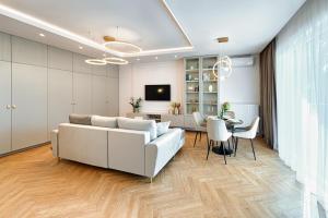 sala de estar con sofá blanco y mesa en Wyjątkowy Taupe Apartament w centrum Łodzi, en Łódź