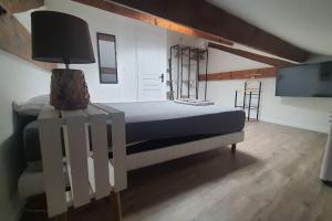 a bedroom with a bed with a lamp and a tv at Beau T3 au cœur du centre ville in Narbonne