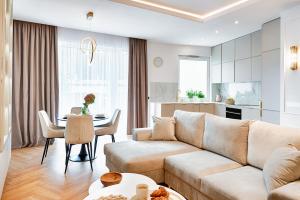 a living room with a couch and a table at Wyjątkowy Taupe Apartament w centrum Łodzi in Łódź