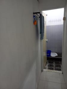 a bathroom with a door leading to a toilet at Homestay Berkah Syariah Bukittinggi in Bukittinggi