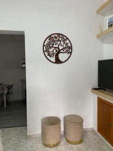 un reloj en una pared blanca con dos taburetes en La Casita de Mari, en Estepona