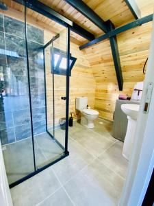 a bathroom with a glass shower and a toilet at Garden Bungalow in Antalya