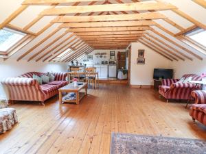 een woonkamer met banken en een houten vloer bij Mrs Delaney's Loft in Ardfinnan