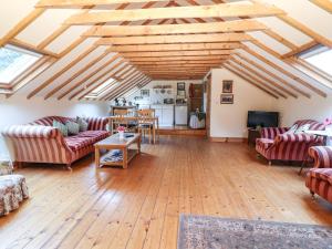 a living room with couches and a wooden floor at Mrs Delaney's Loft in Ardfinnan