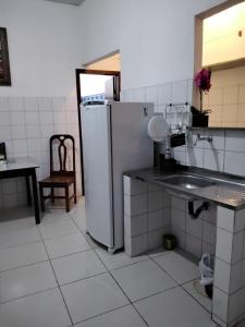 een keuken met een koelkast en een wastafel bij Suíte 10 Privativa e Aconchegante in Cuiabá