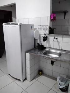 een kleine keuken met een wastafel en een koelkast bij Suíte 10 Privativa e Aconchegante in Cuiabá