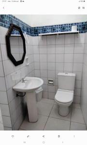 een badkamer met een toilet, een wastafel en een spiegel bij Suíte 10 Privativa e Aconchegante in Cuiabá