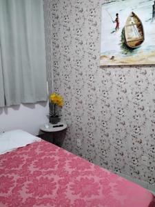 een slaapkamer met een bed en een schilderij aan de muur bij Suíte 10 Privativa e Aconchegante in Cuiabá