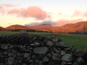 a stone wall in a field with mountains in the background at Garth Engan Private Self Contained B&B with Garden Area in Llanbedr