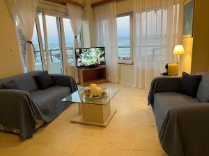a living room with two couches and a television at Sea Breeze in Kalamaki Chanion