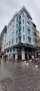 un grand bâtiment bleu dans une rue de la ville dans l'établissement Boss To Hotel Taksim, à Istanbul