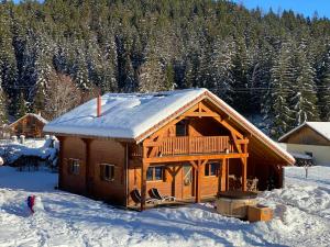 a log cabin with snow on the roof at Le Chalet de la Devinière, bain nordique extérieur chauffé in Xonrupt-Longemer