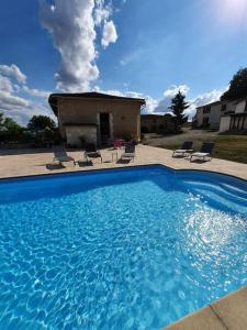 ein großer blauer Pool vor einem Haus in der Unterkunft French Farmhouse Retreat with pool & superb views. in Blanzac