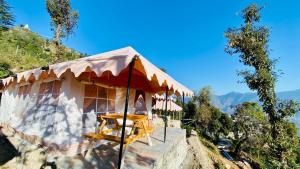 uma tenda no topo de uma montanha com uma mesa em Ananta Prana em Mussoorie