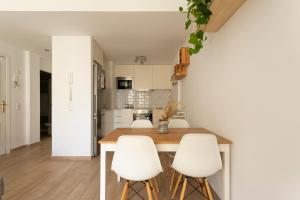 a kitchen with a wooden table and white chairs at Casablanca House in Corralejo
