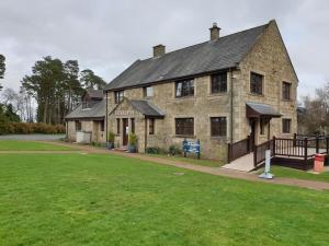 a large stone building with a green field in front of it at The Warrens - 2 bed caravan for 4 & private hot tub in Swarland