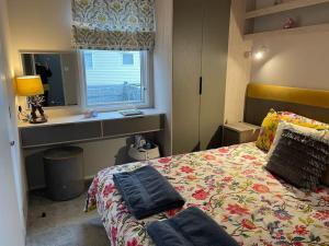a bedroom with a bed and a window at The Warrens - 2 bed caravan for 4 & private hot tub in Swarland