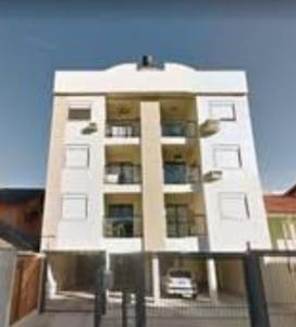 a tall white building with a car in front of it at Apartamento encantador em bairro Nobre. in Santa Cruz do Sul +12 photos