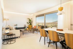 een woonkamer met een tafel en stoelen bij Stunning 3 Bedroom Penthouse in La Cala Golf, Mijas in Málaga