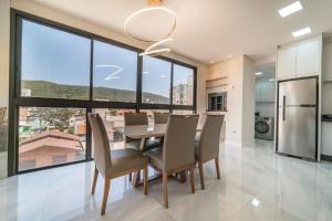- une salle à manger avec une table, des chaises et de grandes fenêtres dans l'établissement Apartamento 2 suítes em Bombas, à Bombinhas