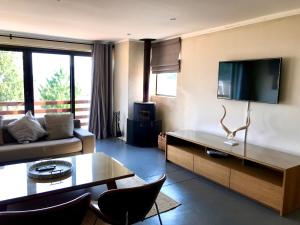 a living room with a couch and a tv at Vetho Farmhouse Dullstroom in Dullstroom