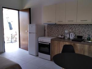 een keuken met een koelkast, een wastafel en een tafel bij Kamares View (Γαλήνη) in Ayeranós +18 foto's