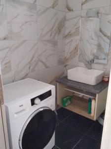 een badkamer met een wasmachine en een wastafel bij Kamares View (Γαλήνη) in Ayeranós