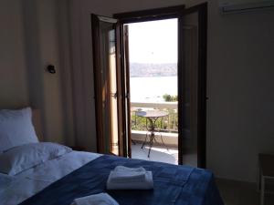 een slaapkamer met een bed en een deur naar een balkon bij Kamares View (Γαλήνη) in Ayeranós