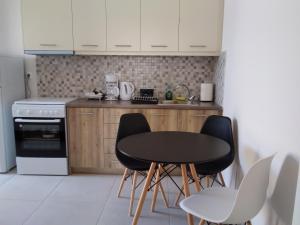a kitchen with a black table and chairs in it at Kamares View (Γαλήνη) in Ayeranós