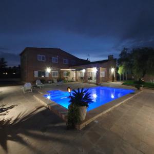 a backyard with a blue swimming pool at night at Maravisa in Puebla de Vallbona