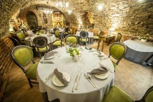 a dining room with white tables and green chairs at Piwnica Rycerska Kęty in Kęty