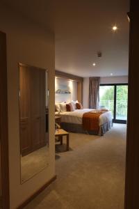 a hotel room with a bed and a sliding glass door at The Teifi Waterside Hotel in Cardigan