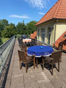 a patio with a table and chairs on a roof at Gutshaus Wohlenhagen in Wohlenberg