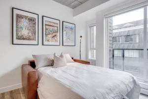 um quarto branco com uma cama grande e uma janela em Initial / New Yorker / Centre-ville de Québec em Cidade de Quebec