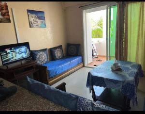 a living room with a blue couch and a tv at Superbe appartement avec piscine in Mohammedia