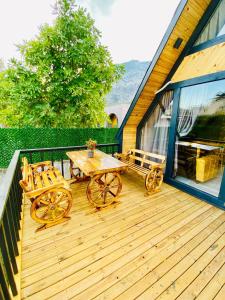 eine Holzterrasse mit einem Tisch und 2 Stühlen in der Unterkunft Garden Bungalow in Antalya