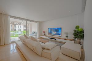 uma sala de estar com um sofá e uma televisão de ecrã plano em Mangroovy Seaview 3BR Beach and Pool Free access em Hurghada