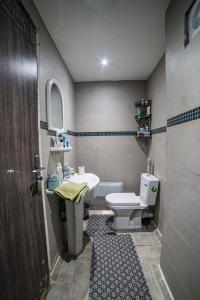 een badkamer met een wit toilet en een wastafel bij Appart Nour Gueliz in Marrakesh