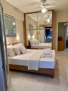 een slaapkamer met 2 bedden en een grote spiegel bij Sea Breeze in Kalamaki