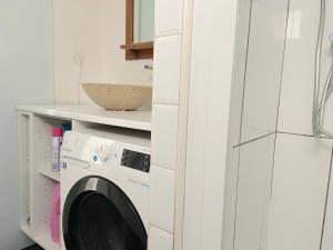 uma cozinha com uma máquina de lavar roupa numa cozinha branca em Cozy house for 8 people near LILLE em Tourcoing