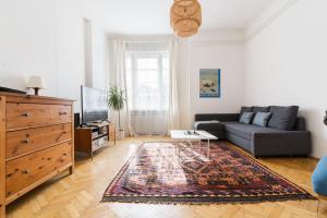 a living room with a couch and a rug at Klauzal apartment w/3 bedrooms, french balcony in Budapest