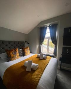 a bedroom with a large bed with towels on it at 3 West End Boutique Apartment in Bowness-on-Windermere