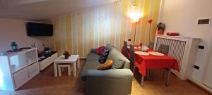 DINO IL MANSARDINO في Ome: غرفة معيشة مع أريكة وطاولة حمراء