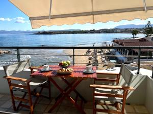 uma mesa e cadeiras numa varanda com vista para a água em Sea Breeze em Kalamaki