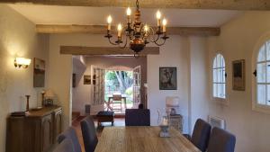 una sala da pranzo con tavolo, sedie e lampadario pendente di Villa Vuyani Antibes a Antibes