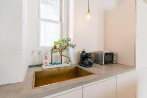 a kitchen with a sink and a microwave at Klauzal apartment w/3 bedrooms, french balcony in Budapest