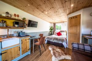 Habitación pequeña con cama y cocina con mesa. en Coorie In en Kilmore