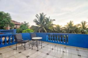 uma varanda com cadeiras e uma cerca azul em Hilltop 4BHK Villa with Private Pool Near Candolim em Old Goa