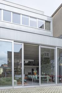 a building with large glass windows and a patio at Mari's: Multifunctional Shelter with big Garden in Ghent