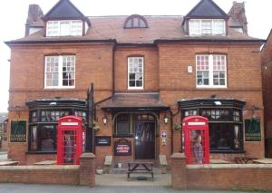 a brick building with three red phone booths at Fifteens of Swinley in Wigan